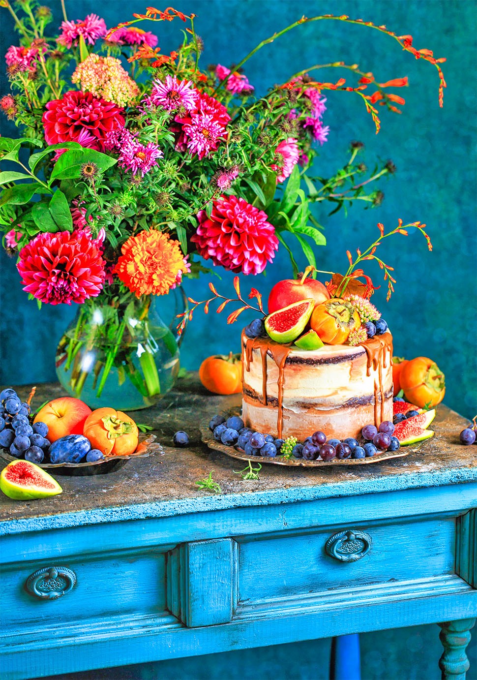 Cake with fruit, blue table, flowers
