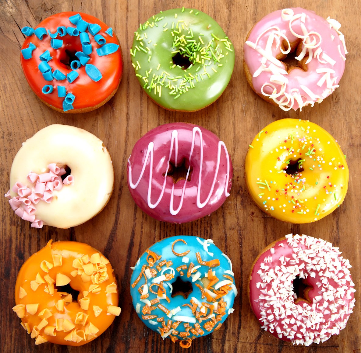 Colorful doughnuts on wooden surface