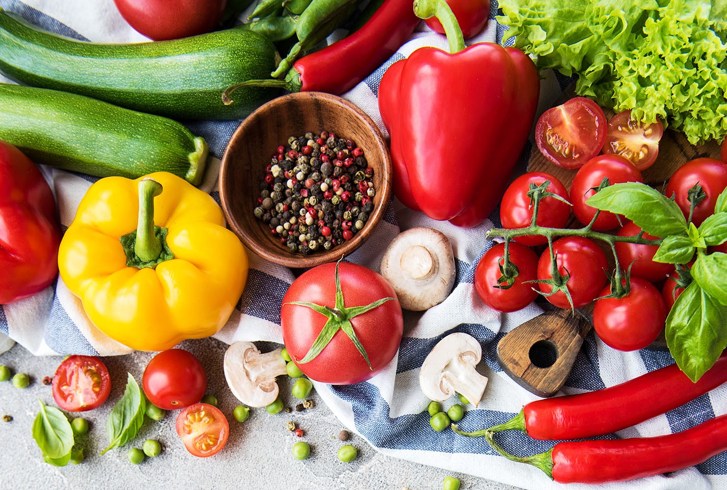 Fresh produce photo, red peppers, green cucumbers, blue and white tablecloth