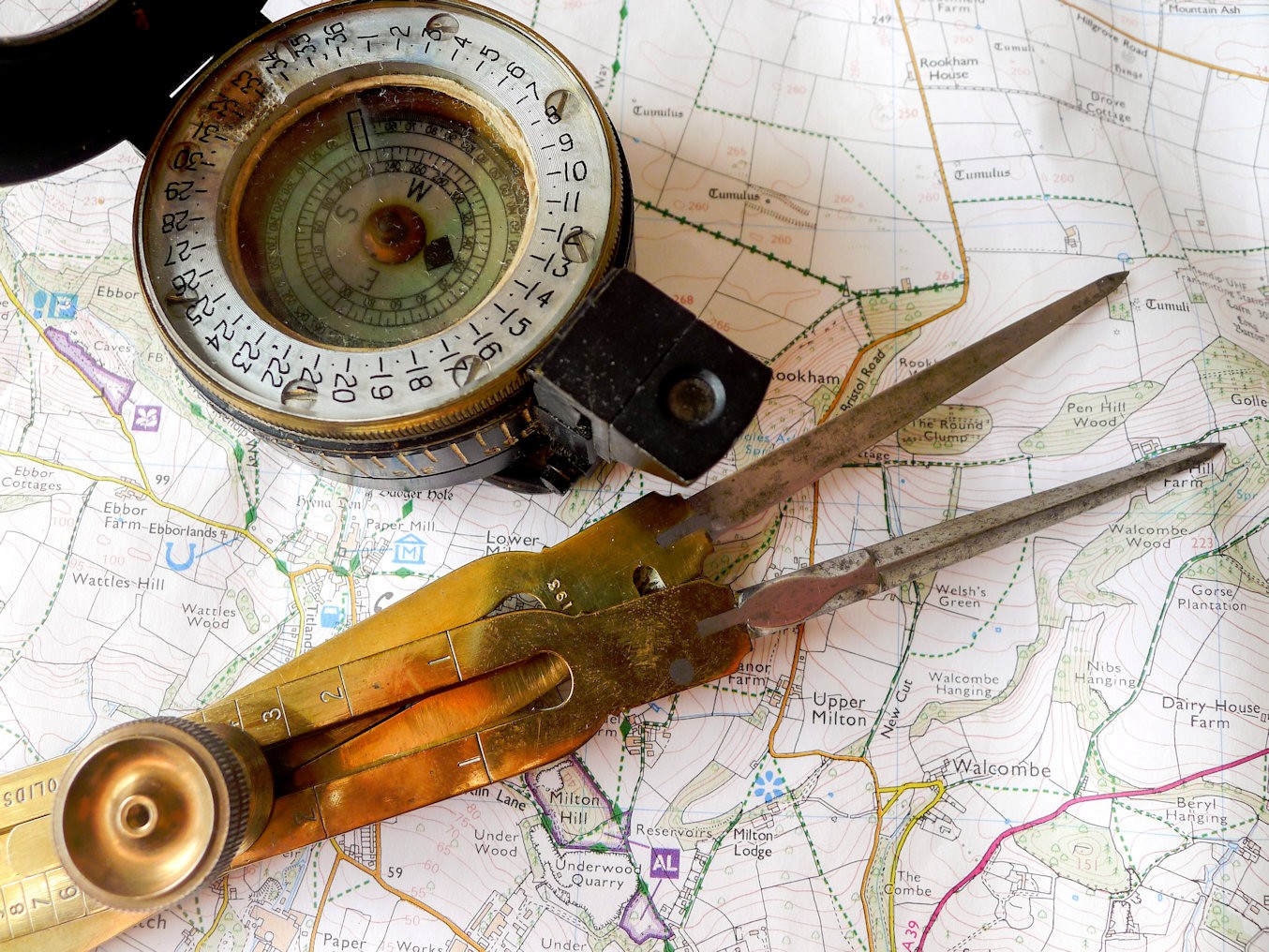 Old compass and scissors on map